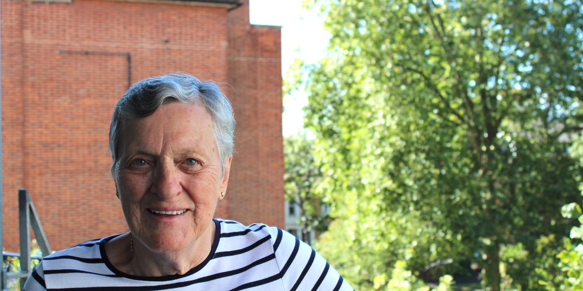 A smiling woman with trees in the background.