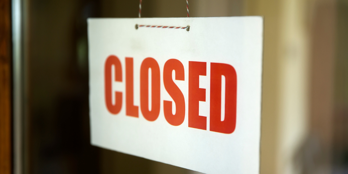 A closed sign hangs in a window.