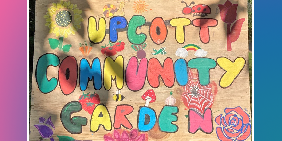 A painted wooden sign for Upcott Community Gardens