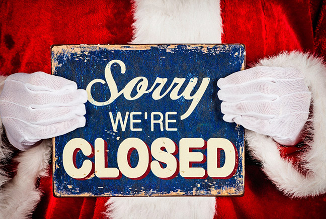 Santa holding a 'Sorry, we are closed' sign