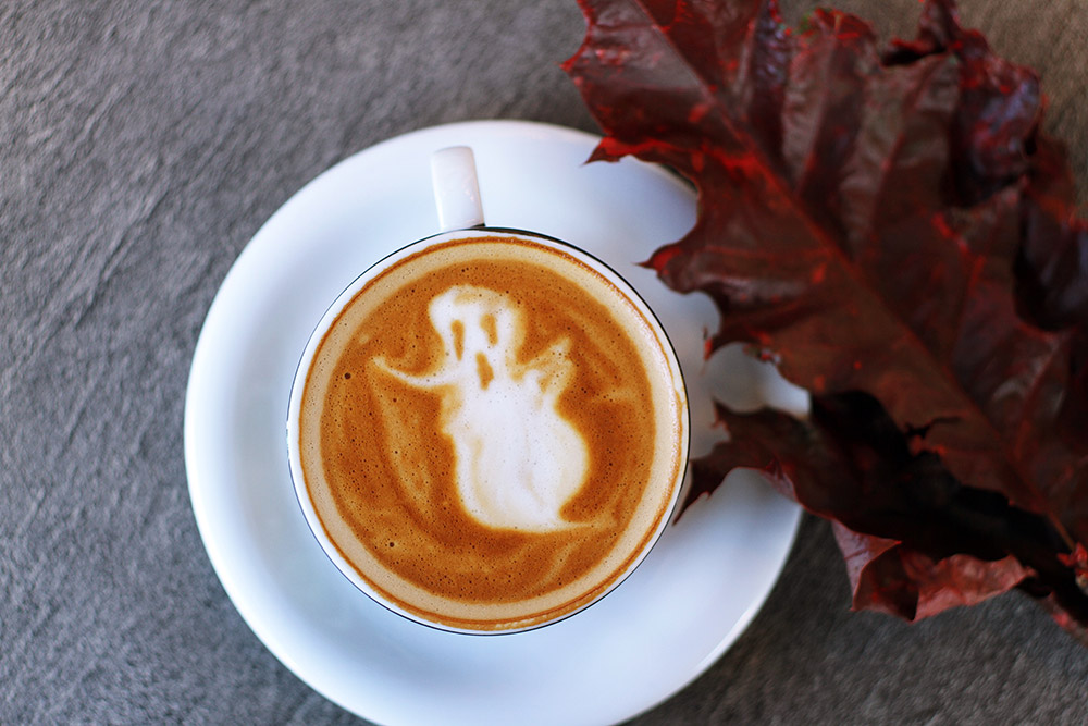 A cup of coffee with a ghost latte art