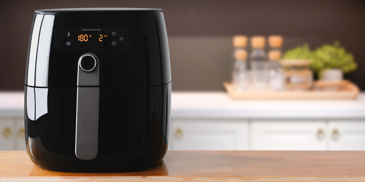 A switched-on air fryer on a kitchen counter.