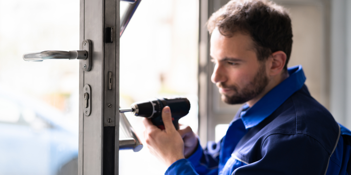 A man using a drill to change a door lock.