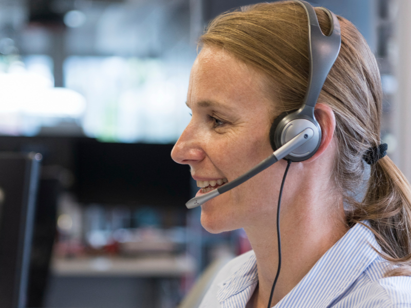 A woman wearing a headset takes a call. 