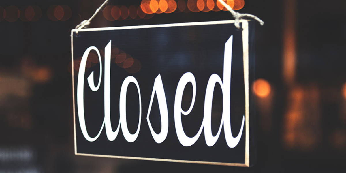 A closed sign hanging in a window.