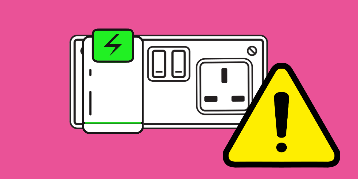 An electrical device in a plug socket with a warning sign in front of it.