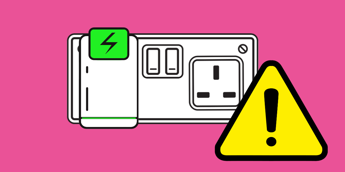 An electrical device in a plug socket with a warning sign in front of it.